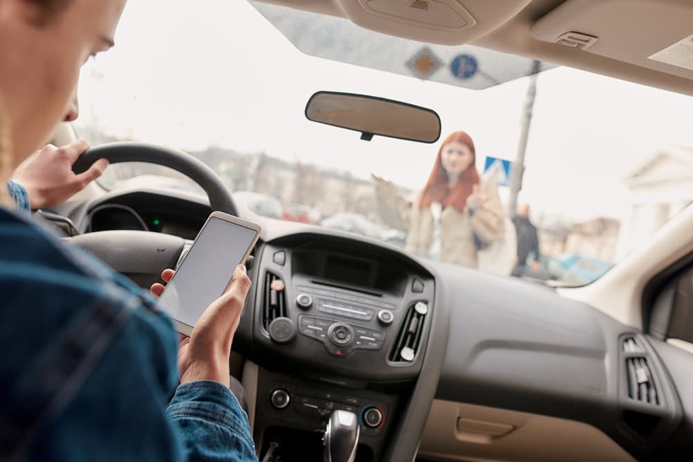 Distracted driver checking his cell phone